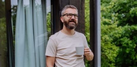 Mann mit Kaffeebecher in der Hand